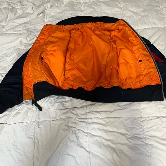 Navy blue bomber jacket With orange inside 
Goes for $300
Flips inside out - Picture 2 of 7